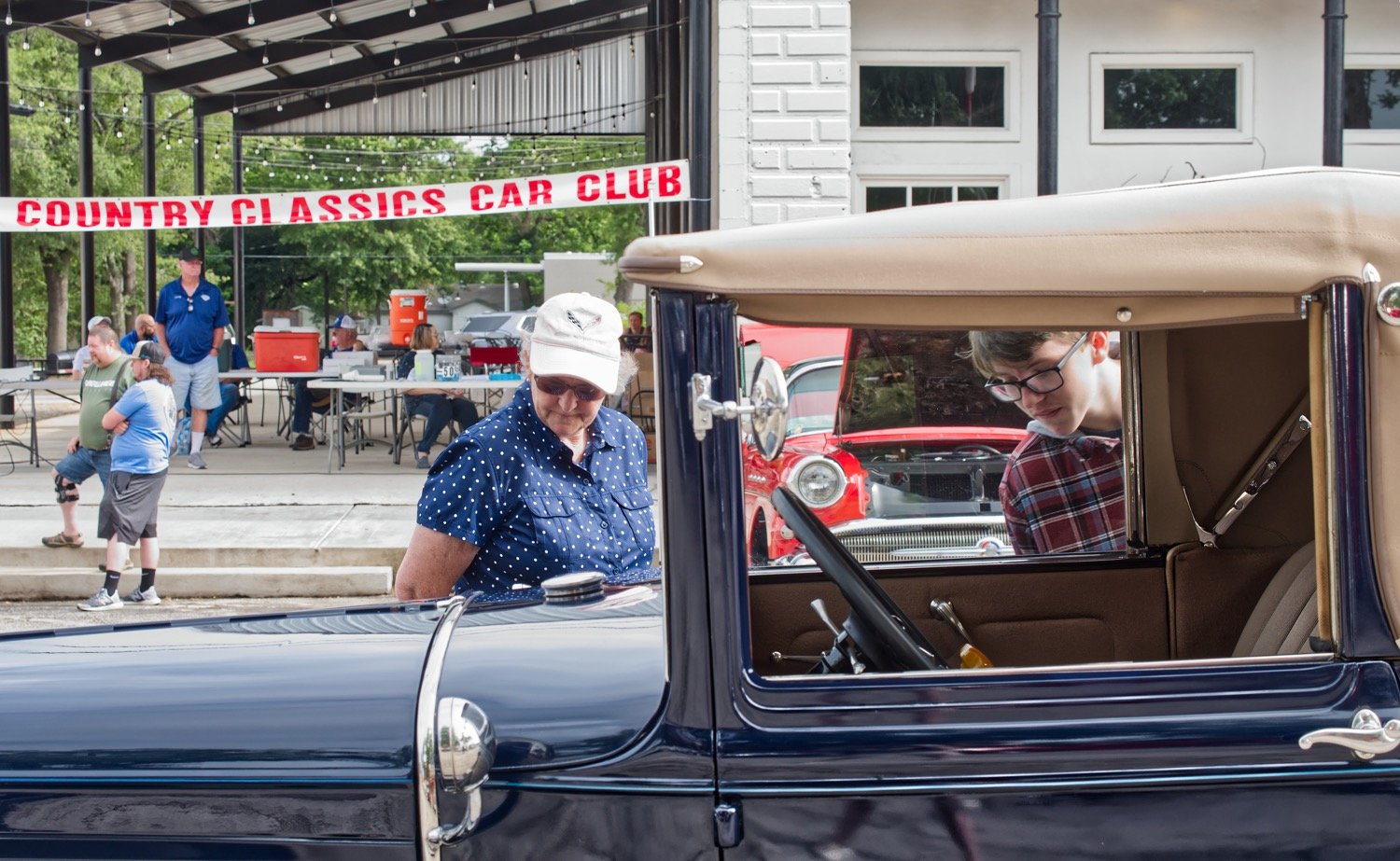 Janet Judkins and Jackson Friddle get a closeup look at an antique Ford Saturday morning at the courthouse square in Quitman. Lake Country Classic Cars put on the show which has been delayed by COVID-19 restrictions since March.